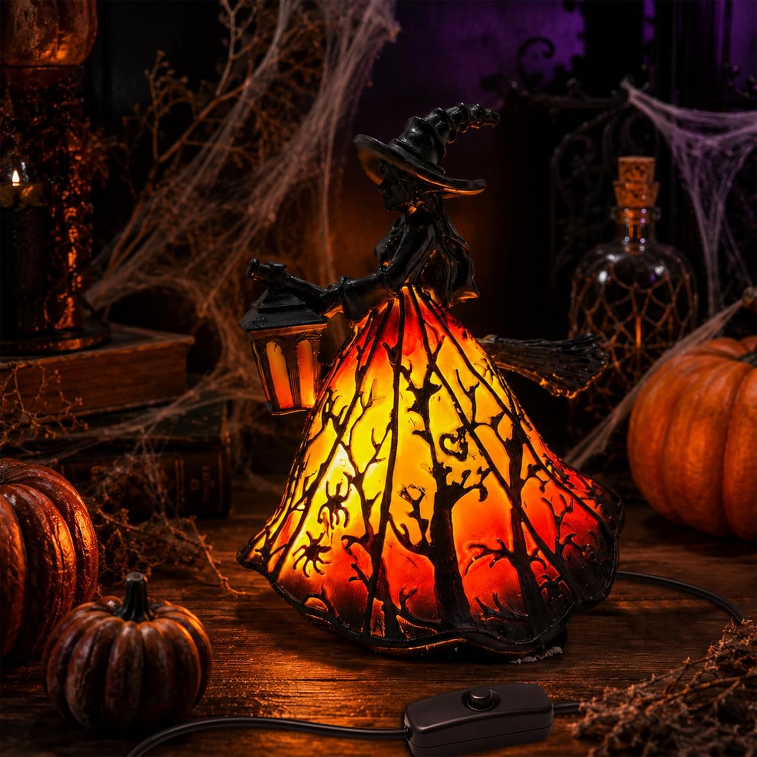 USB-powered witch figurine lamp, her stained-glass-effect skirt glowing orange with a silhouetted haunted forest scene, lantern in hand