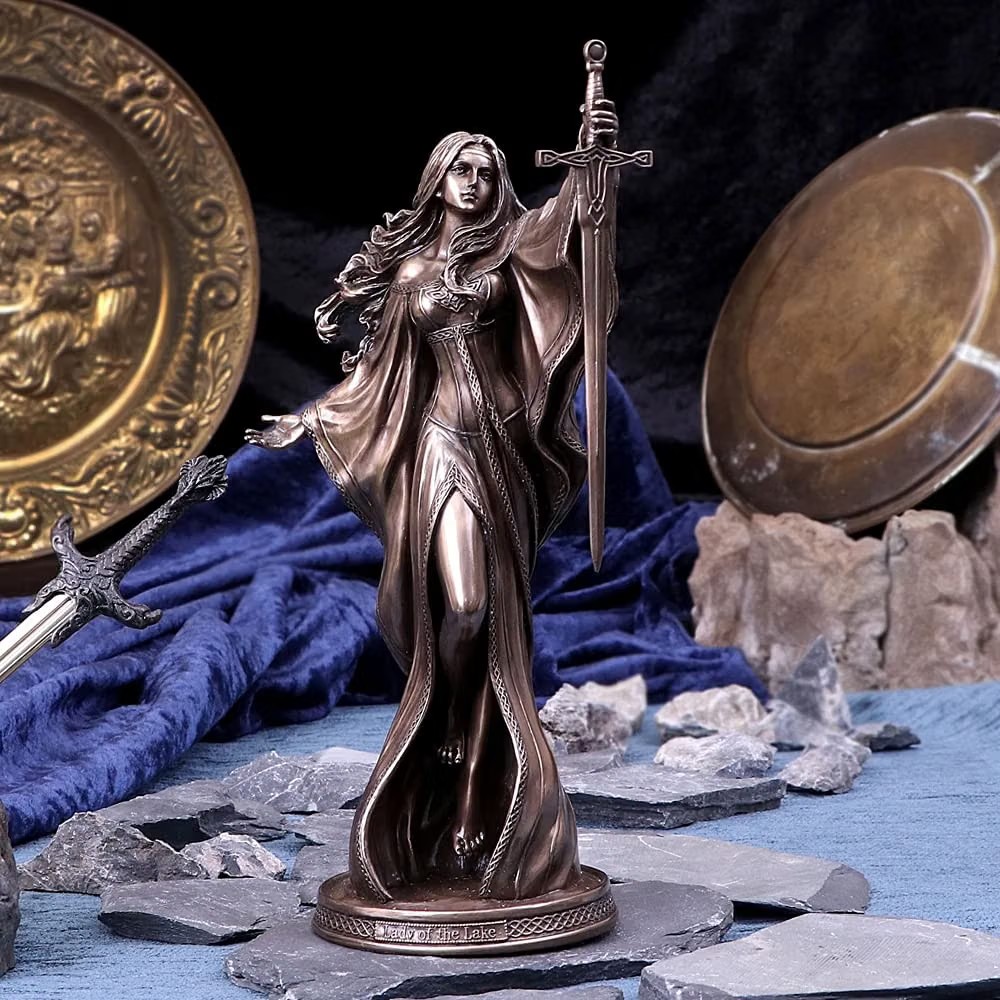 Bronze-finish Lady of the Lake figurine, a robed woman rising from stone with a sword raised overhead