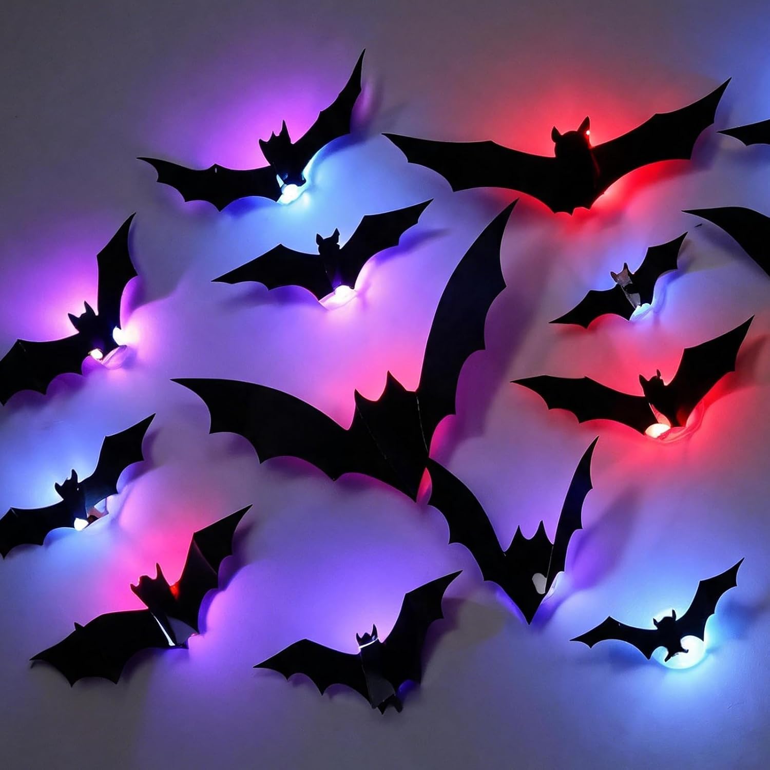 12 piece set of 3D black bat wall stickers with colour-changing LED night lights glowing purple and red behind each bat