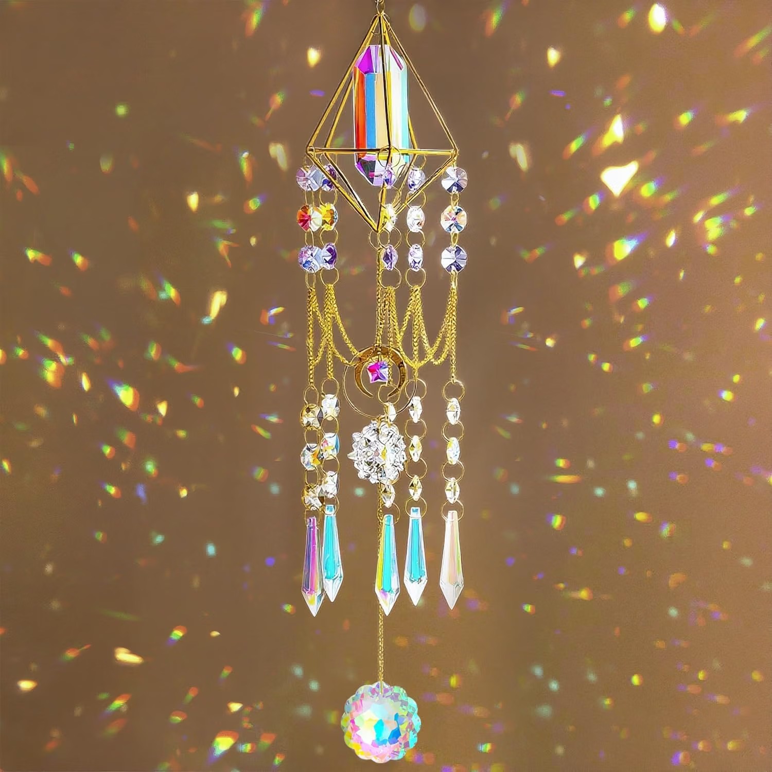 Aura crystal point suncatcher in a gold geometric frame, hung with faceted crystal prisms and a large iridescent crystal ball