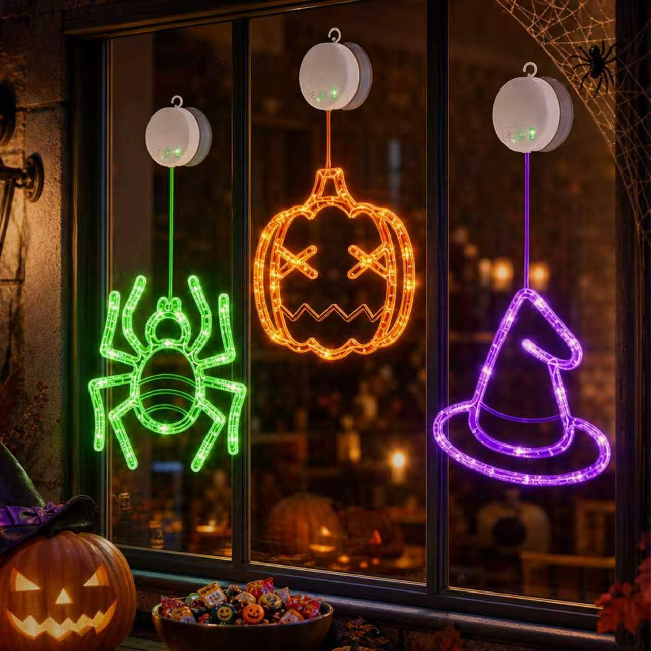 Three LED window hanging lights shaped like a pumpkin, spider, and witch hat