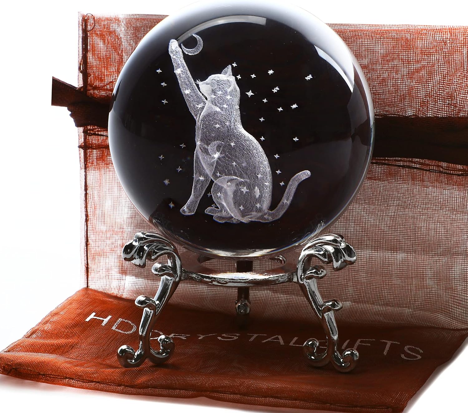 Clear crystal ball engraved inside with a cat reaching up among stars and moons, on a silver-tone stand