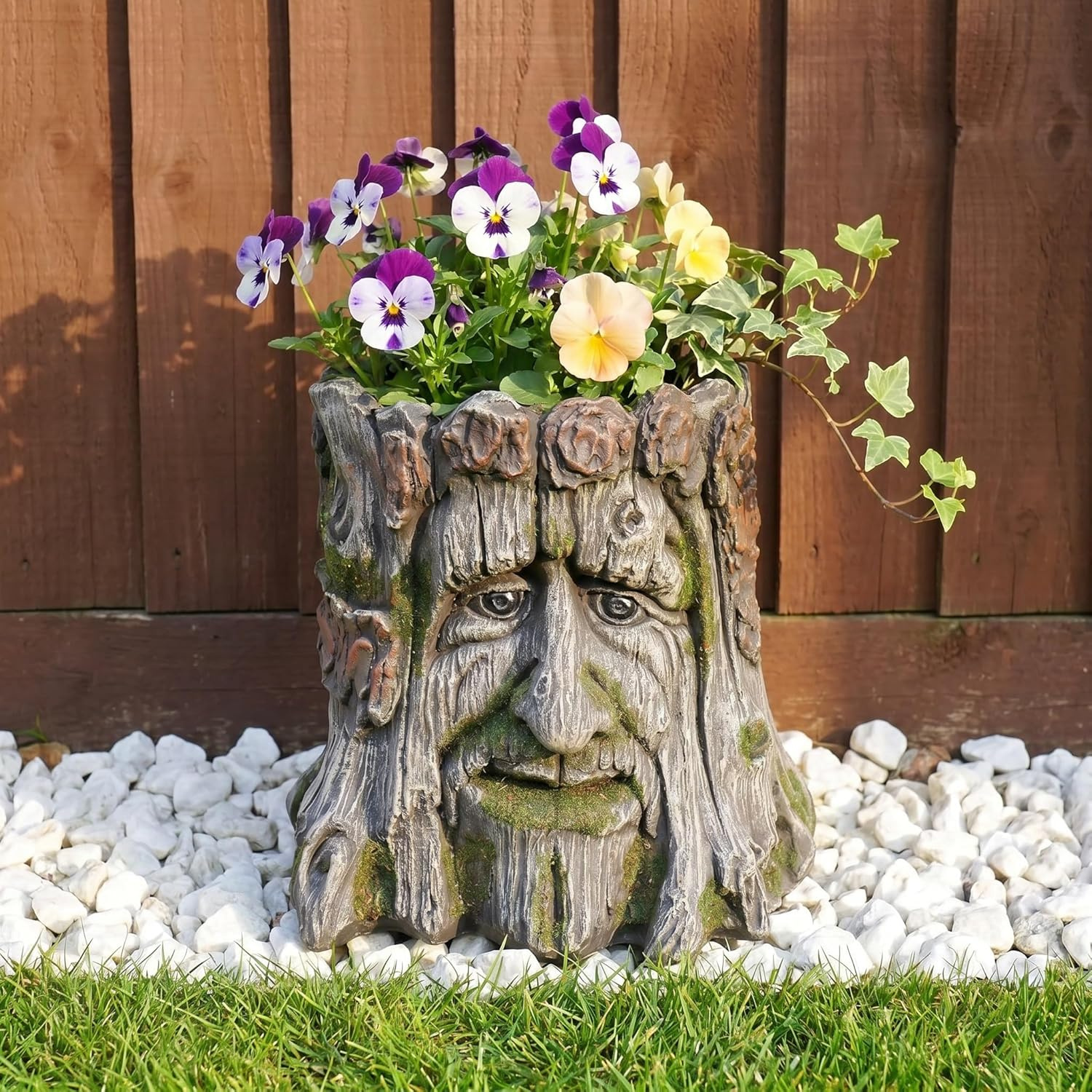 Weathered tree-stump planter carved with a woodland Green Man face
