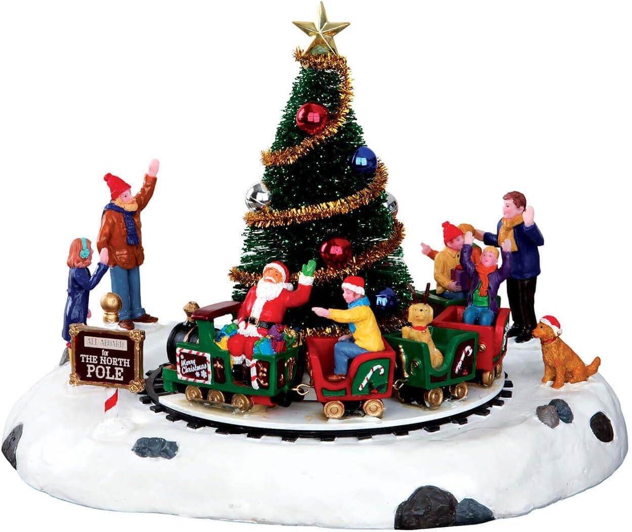 Lemax Santa's Kiddie Train village piece, with Santa driving a little train of children and a puppy around a decorated Christmas tree on a snowy base, as waving villagers look on beside an All Aboard for the North Pole sign