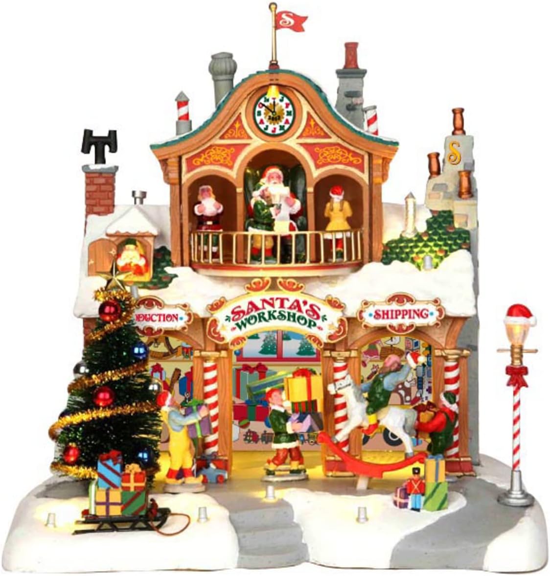 Lemax Santa's Workshop village building with a clock tower, Santa reading his list on the balcony, elves carrying presents and a rocking horse below, a decorated tree, and a candy-cane lamppost