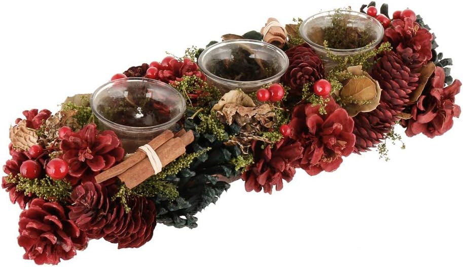 Long Christmas centrepiece of red-dyed pine cones, berries, cinnamon sticks and greenery holding three glass tealight cups