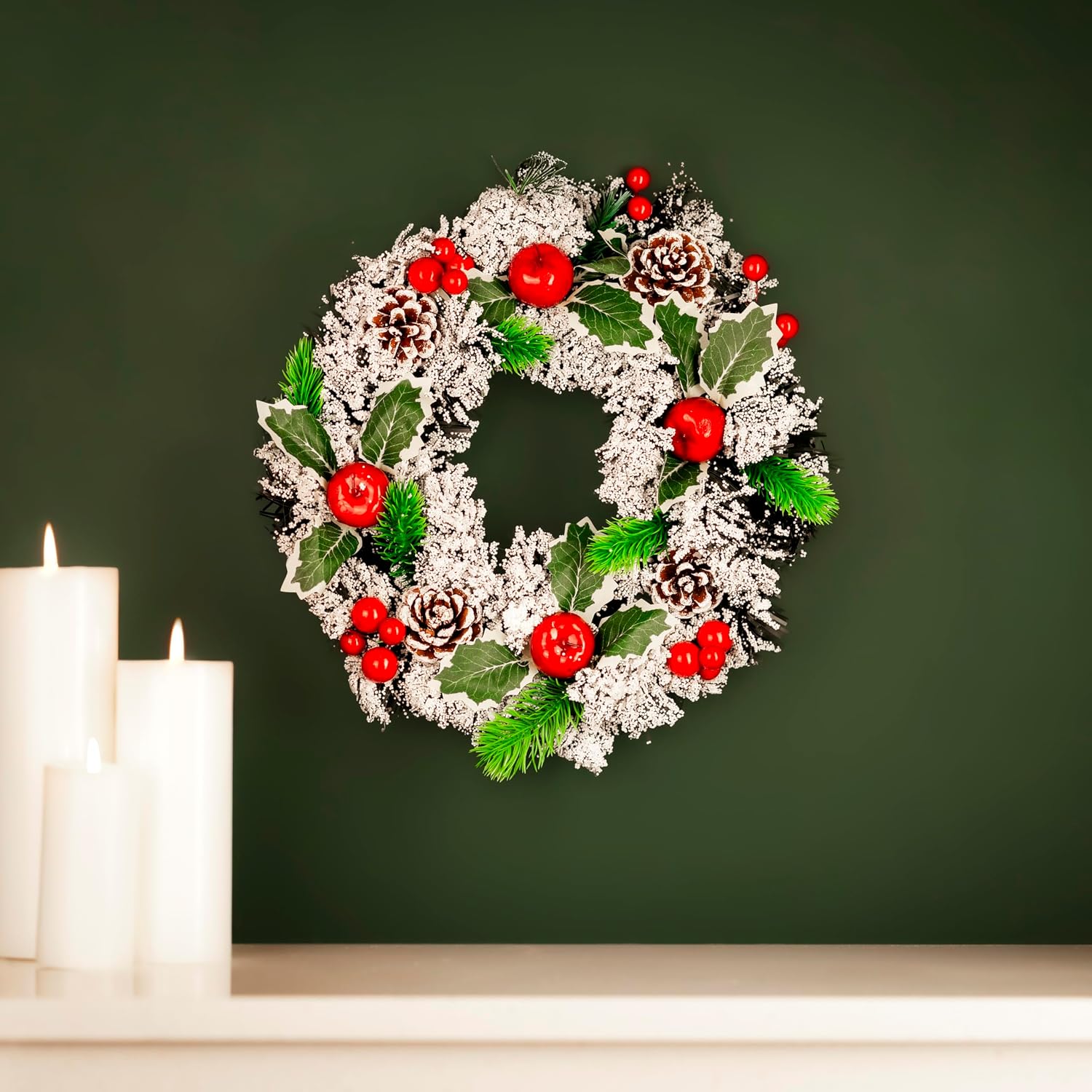 Snow-flocked Christmas wreath with pinecones, berries and mistletoe