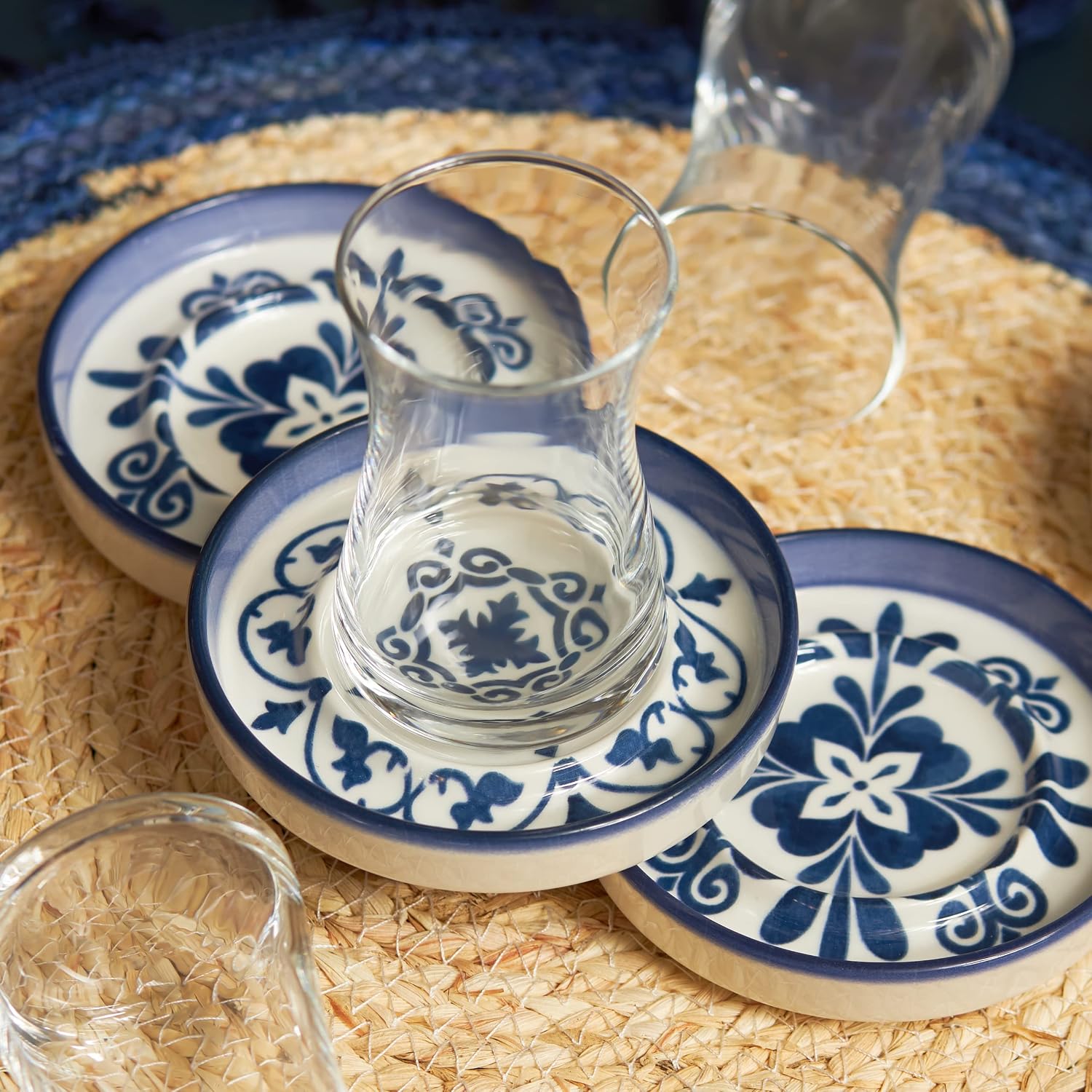 Clear tulip-shaped Turkish tea glasses on blue and white patterned stoneware saucers